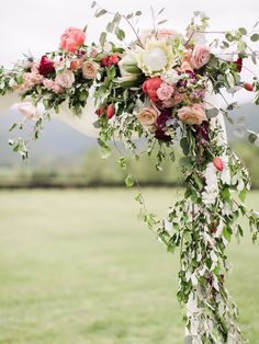 a wedding arch decorated with flowers and greenery