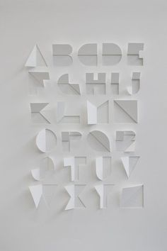 the letters are cut out of paper and placed on top of each other in different shapes