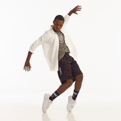 a man in white shirt and shorts doing a dance move