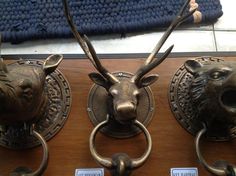 three metal deer head knobs on the front of a door