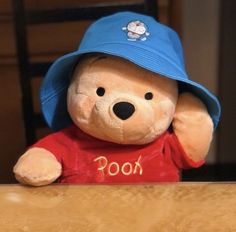 a teddy bear wearing a blue hat sitting at a table