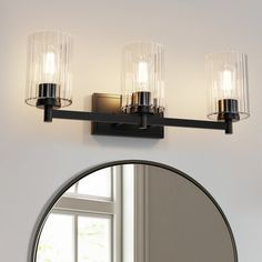 a bathroom light with three lights on the wall above it and a mirror in front of it