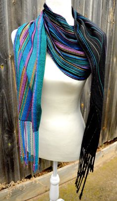 a white mannequin wearing a multicolored scarf