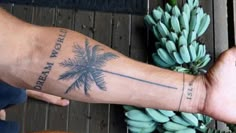 a person with a palm tree tattoo on their arm