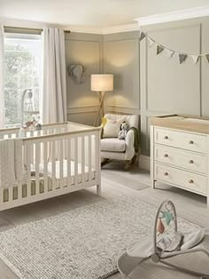 a baby's room with a crib, dressers and bed in it