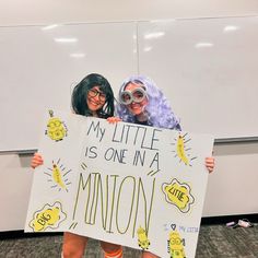 two women holding up a sign that says my little is one in a minion