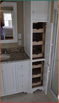 a bathroom with white cabinets and marble counter tops