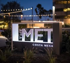 the met costa mesa sign is lit up at night