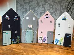 three small houses are painted with different colors and designs on the front, side, and back sides