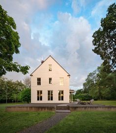 a white house sitting on top of a lush green field