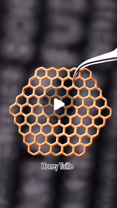 an orange honeycomb is being held up by a white toothbrush with the words honey tuttle on it