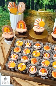 cupcakes are arranged in the shape of rainbows on a table with other decorations