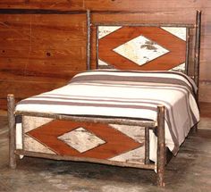 a small bed with a wooden headboard and foot board in a room that has wood paneling on the walls