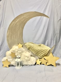 the moon, stars and lantern are sitting on top of the white sheeted backdrop