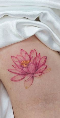 a pink flower on the back of a woman's stomach, with yellow stamen