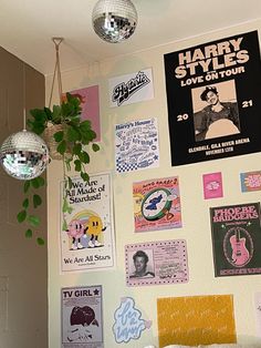 a bedroom with posters and disco balls on the wall, plants hanging from the ceiling