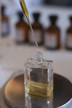 a small glass bottle filled with liquid on top of a metal tray next to bottles