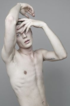 a shirtless man with his hands on his head