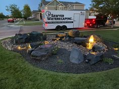 a truck parked next to a fire pit in the middle of a yard at night