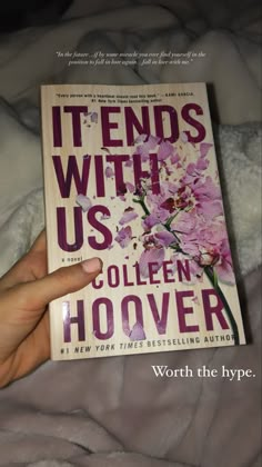 the book it ends with us by collien hoover is in someone's hand