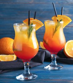 two glasses filled with orange juice and garnished with rosemary on the rims