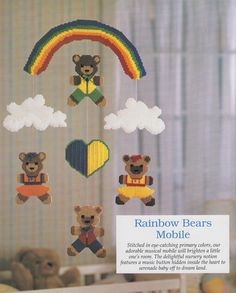 a cross stitch mobile with teddy bears hanging from it's sides and rainbow bears on the other side