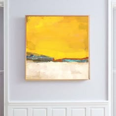 an abstract painting hangs on the wall above a chair in a living room with white walls