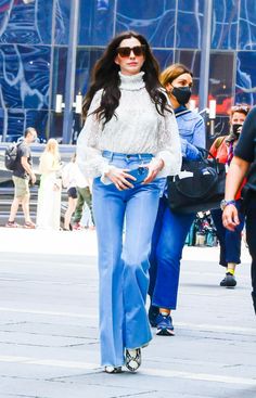 a woman walking down the street in high rise jeans