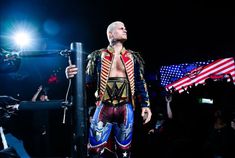 a man dressed in costume standing next to an american flag