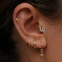 an ear with three different types of piercings on the top and bottom of it