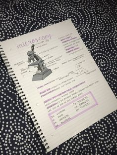 a notebook with an image of a microscope on it and the words microsy compy written in purple ink