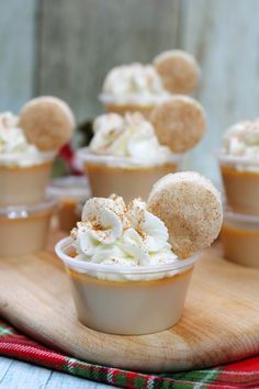 several dessert cups with whipped cream and mickey mouse ears in them on a wooden tray