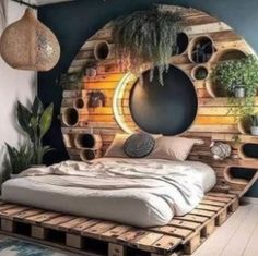 a bed made out of wooden pallets with plants in the middle and round mirrors above it