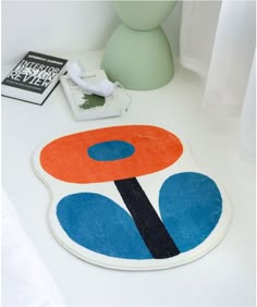 a white table topped with a blue and orange rug