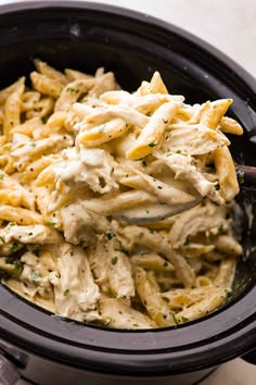 a black bowl filled with pasta and chicken salad