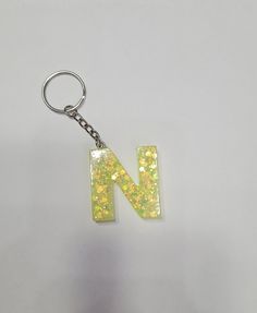 the letter n is made out of plastic and has yellow glitter on it's side