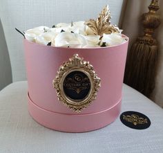 a pink hat box with white roses in it