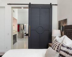 a bedroom with white walls and black doors