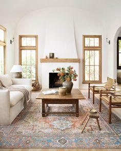 a living room filled with furniture and a fire place in the middle of a room