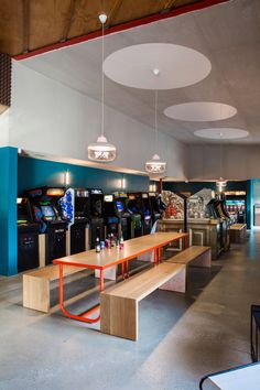 a room filled with tables and arcade machines