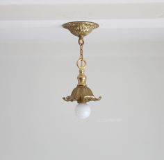 a light fixture hanging from the ceiling in a room with white walls and flooring