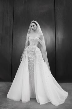 a black and white photo of a woman in a wedding dress with veil on her head