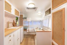 a narrow kitchen with white cabinets and wood flooring