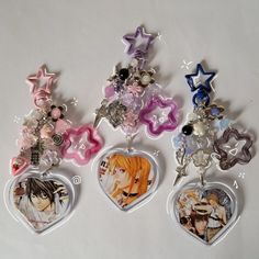 four heart shaped key chains with anime characters on them