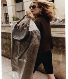 a woman walking down the street carrying a plastic bag