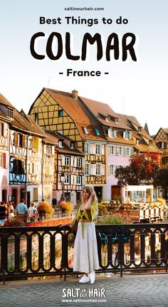 a woman standing on top of a bridge in front of buildings with the words best things to do colmar - france