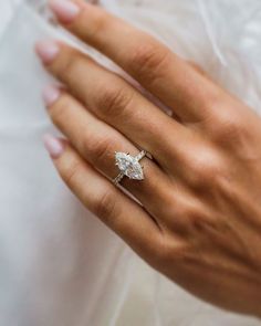 a woman's hand wearing a diamond ring