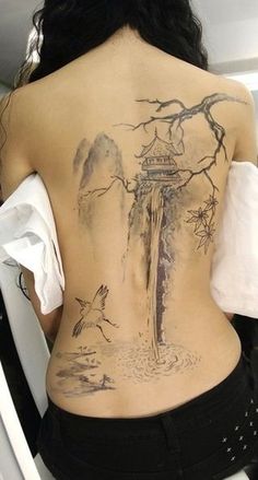 the back of a woman's body with tattoos on it