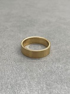 a gold ring sitting on top of a gray surface