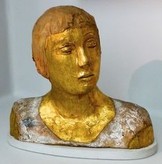 a gold colored statue of a woman's head